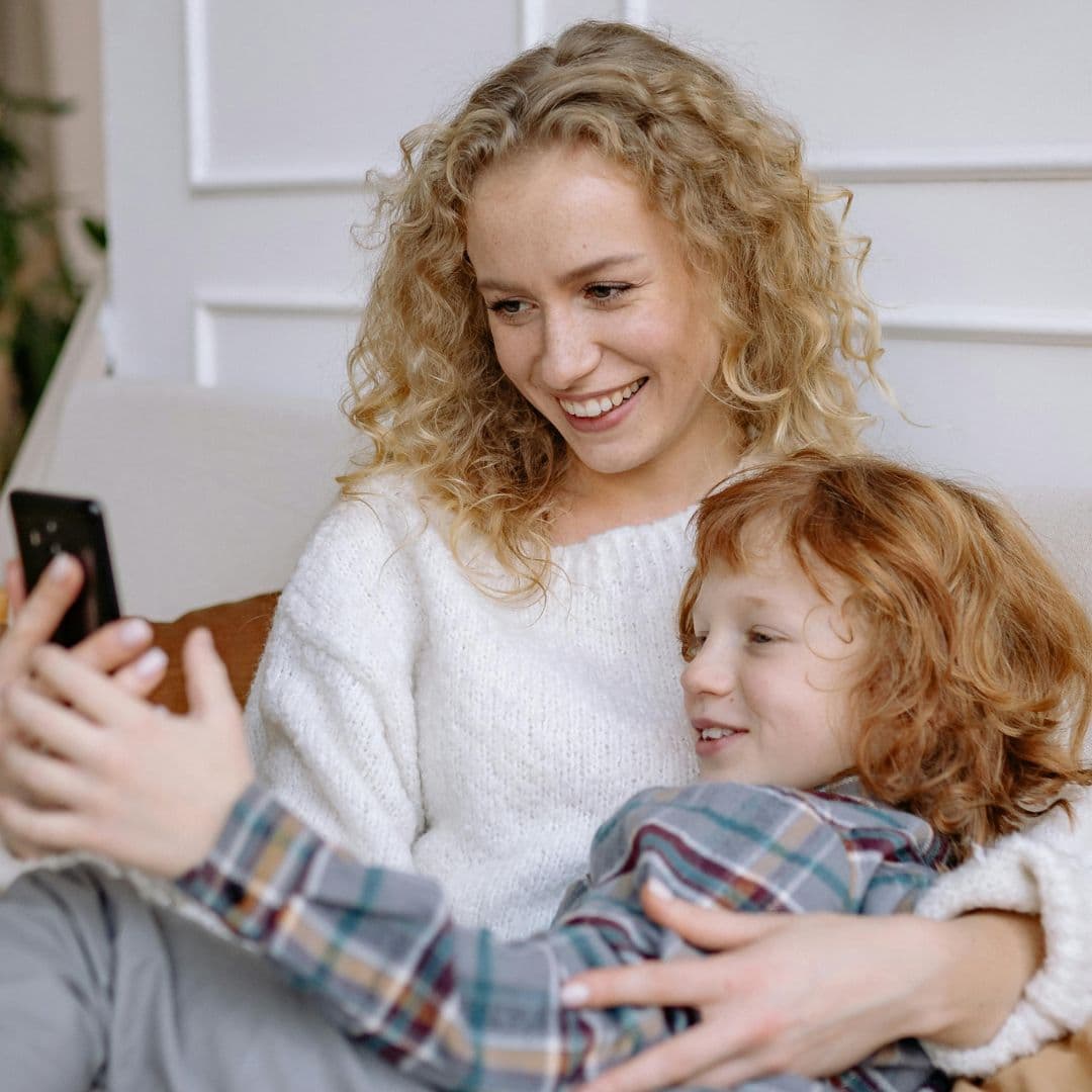 Mutter und Kind schauen gemeinsam aufs Handy